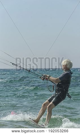 Porto Paglia Italy - October 03 2016: Greybeard keeps active by practicing water sport