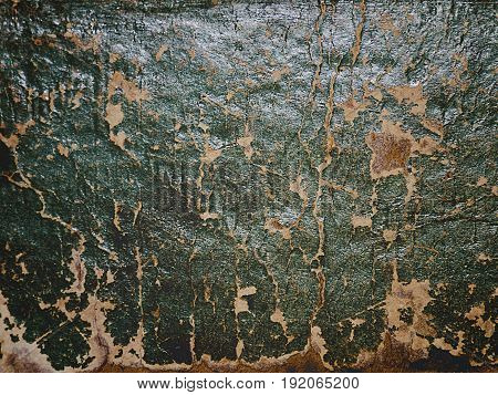 Cracking and peeling green paint on a wall. Vintage wood background with peeling paint. Old board with Irradiated paint