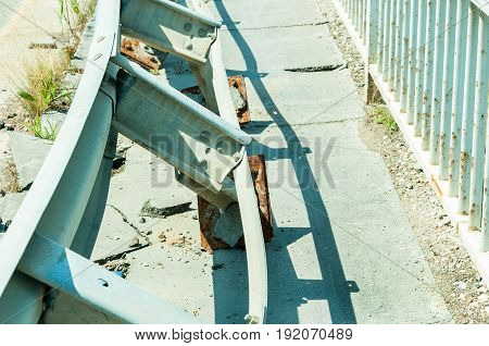 Damaged security steel fence on the bridge from car crash accident. Selective focus. Damaged bridge in car crash accident.