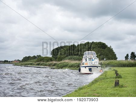 docked yaught on lake near Sneek in dutch province of friesland during summer storm