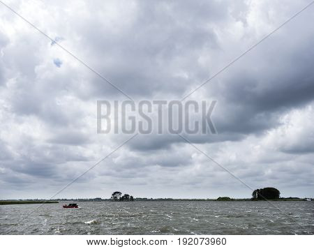 lonely wooden vessel during summer storm on lake near sneek in dutch province of friesland in the netherlands