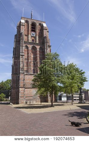 old lopsided tower oldehove tower and dog in the centre of leeuwarden capital of friesland in the netherlands with blue sky