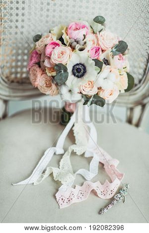 Wedding accessories: boutonniere and bride's bouquet on the chair