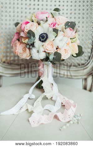 Wedding accessories: boutonniere and bride's bouquet on the chair