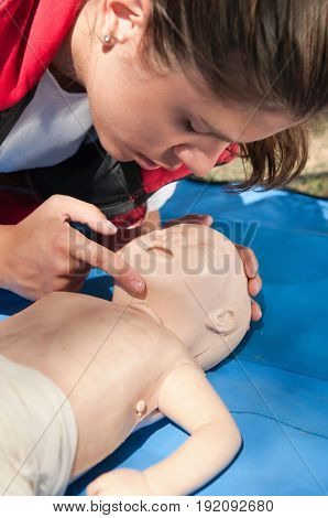 Checking Vital Functions On Infant Dummy Outdoors, Color Image, One Woman Only