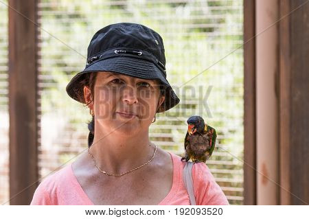 Young woman feeds parrots at the Australian Zoo Gan Guru in Kibbutz Nir David in Israel