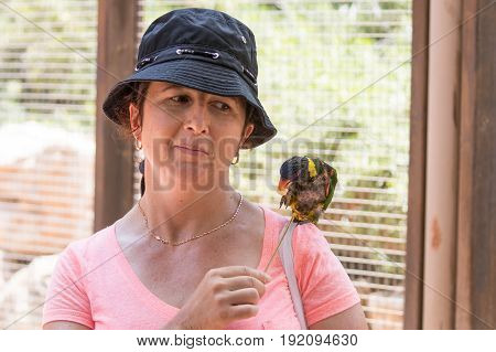 Young woman feeds parrots at the Australian Zoo Gan Guru in Kibbutz Nir David in Israel