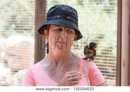 Young woman feeds parrots at the Australian Zoo Gan Guru in Kibbutz Nir David in Israel