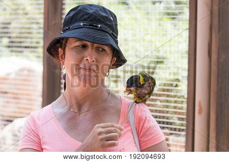 Young woman feeds parrots at the Australian Zoo Gan Guru in Kibbutz Nir David in Israel
