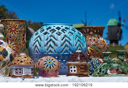 Candlesticks in the shape of a lodge and a glob colorful decorative vases handmade on a blue sky background