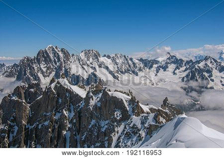 View of snowy peaks from the Aiguille du Midi, in French Alps Chamonix Mont Blanc, alpine mountains landscape, clear blue sky in warm sunny summer day