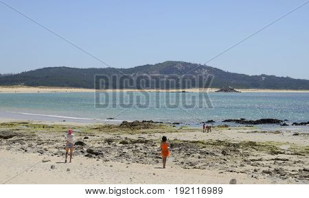 CORRUBEDO, SPAIN - AUGUST 10, 2016: People in a fine sand beach in Corrubedo Corunna Galicia Spain
