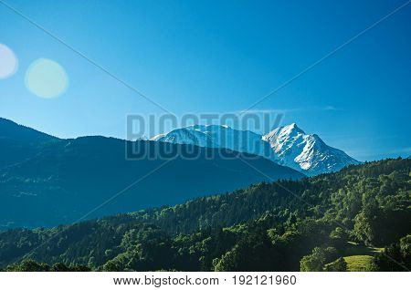 Forest, alpine landscape and blue sky in the background, Saint-Gervais-Les-Bains, French Alps