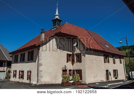 House with small tower in the village of Thorens-Glières, with blue and sunny sky. Located in the department of Haute-Savoie, Auvergne-Rhône-Alpes region, in south-eastern France