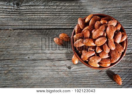 Tasty Almonds Nuts In Wooden Bowl On The Old Background With Place For Text. Top View. Copy Space.