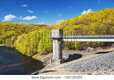 The lake side of Hop Brook Dam in Naugatuck connecticut on a sunny blue sky day.