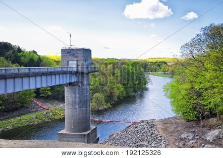 The lake side of Hop Brook Dam in Naugatuck connecticut on a sunny blue sky day.