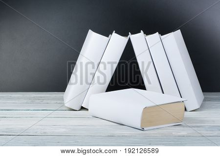 Open black and Whitel books on wooden table, black board background. Back to school. Education business concept