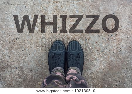 Whizzo british slang for superb and excellent with brand new modern tennis shoes on concrete sidewalk