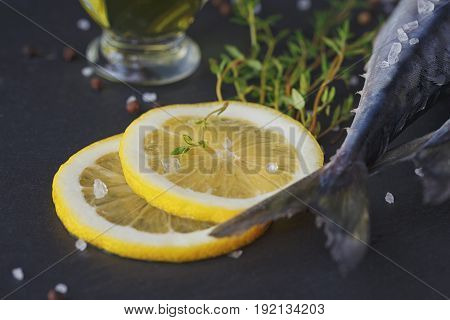 Fresh raw fish mackerel and ingredients for cooking on a dark background in a rustic style. Top view with copy space