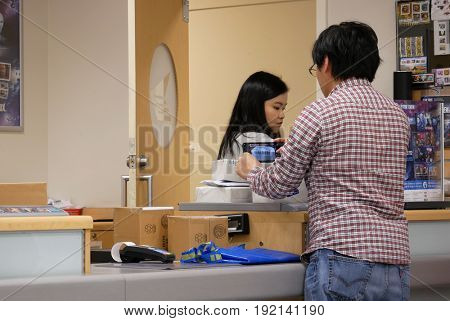 Coquitlam, BC, Canada - May 04, 2017 : Man taking pciture for his parcel at post office