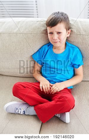 Top view of small boy crying on sofa. Dissapointed small child 