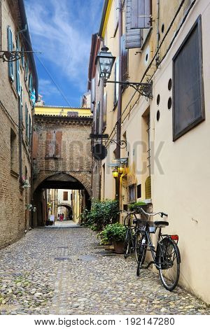 Bicycle parked near the wall of an ancient house in an Old Town of Ferrara, Italy