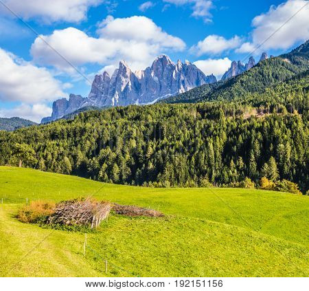 Warm autumn in the Dolomites, the Val de Funes. The valley is surrounded by a dentate wall of dolomite rocks. The concept of ecological tourism