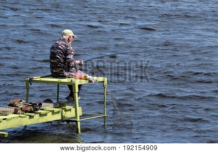 An unidentified person fishing.Modern residential area Obolon.June 21 ,2017 in Kiev, Ukraine