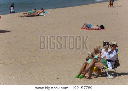 ALVOR, PORTUGAL - APRIL 23, 2017: People at the famous beach of Praia do Alvor, Algarve region, Portugal