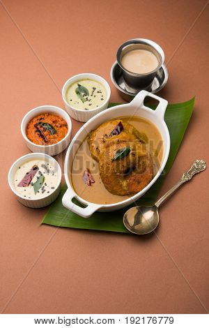 south indian food called vada sambar or sambar vada or wada dipped in sambar with coconut, green and red chutney and south indian style hot coffee, selective focus