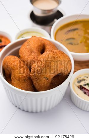 south indian food called vada sambar or sambar vada or wada, served with coconut, green and red chutney over fresg banana leaf, selective focus
