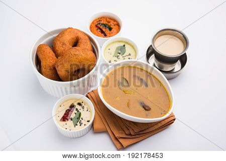 south indian food called vada sambar or sambar vada or wada, served with coconut, green and red chutney over fresg banana leaf, selective focus