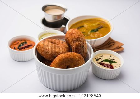 south indian food called vada sambar or sambar vada or wada, served with coconut, green and red chutney over fresg banana leaf, selective focus