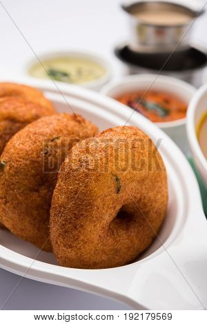 south indian food called vada sambar or sambar vada or wada, served with coconut, green and red chutney over fresg banana leaf, selective focus