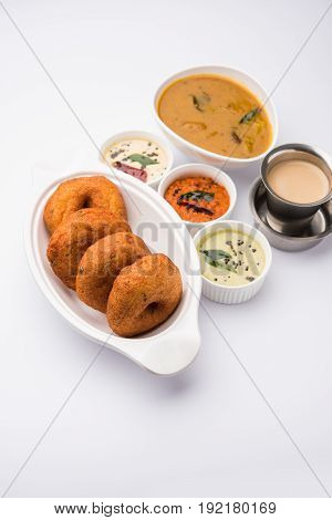 south indian food called vada sambar or sambar vada or wada, served with coconut, green and red chutney over fresg banana leaf, selective focus
