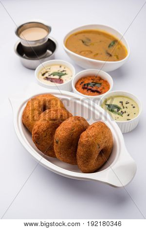 south indian food called vada sambar or sambar vada or wada, served with coconut, green and red chutney over fresg banana leaf, selective focus