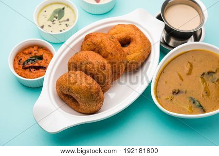 south indian food called vada sambar or sambar vada or wada, served with coconut, green and red chutney over fresg banana leaf, selective focus