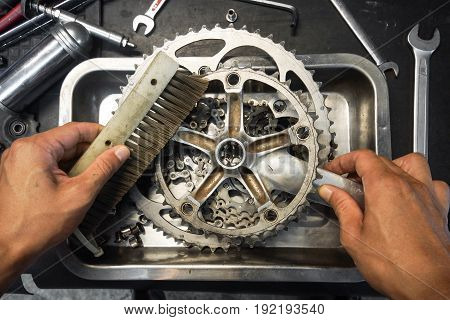 Hand of a mechanic cleaning a bicycle cassette and crankset