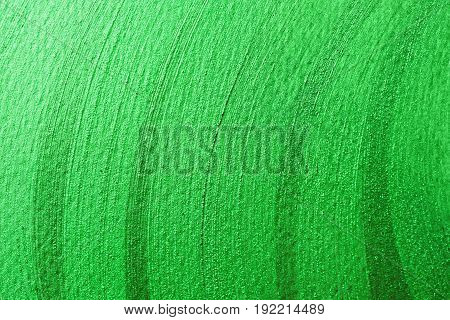 Green melallic shining stroke texture made with brush and paint hand drawn. Golden abstract background. Perfect festive backdrop