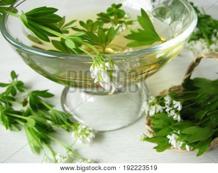 Glass of woodruff bowl, white wine with woodruff leaves