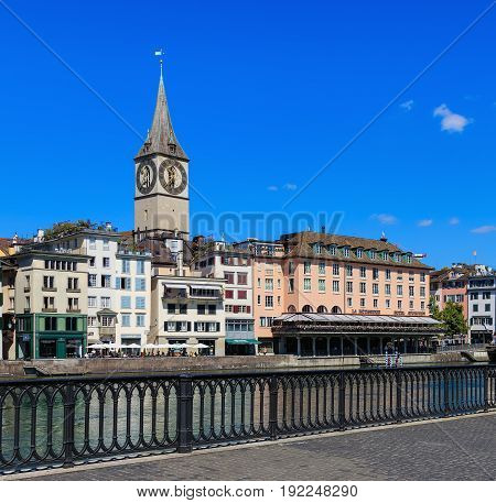 Zurich, Switzerland - 18 June, 2017: old town buildings along the Limmat river, clock tower of the St. Peter Church, Hotel Storchen. Zurich is the largest city in Switzerland and the capital of the Swiss canton of Zurich.