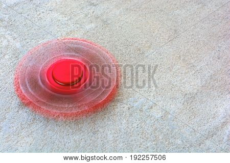 Red fidget spinner stress relieving toy on wooden background