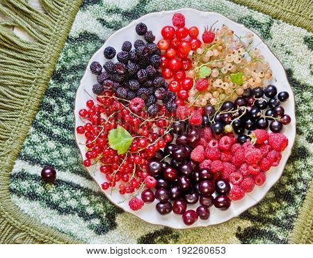 Seven different kinds  of colorful summer berries on the plate