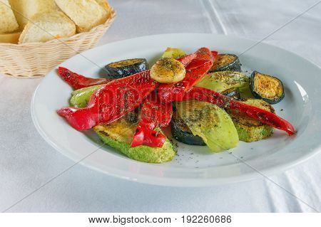 Plate with grilled vegetables on a white tablecloth
