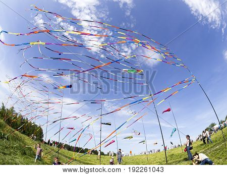 MOSCOW, RUSSIA - JUN 1, 2014: Fluttering in the wind colorful ribbons and colorful kites at the festival of kites with happy people and children around in Moscow Russia.