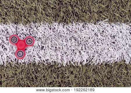 Top view of the popular spinner gadget in 2017 on a green and white artificial lawn