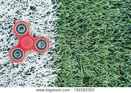Top view of the popular spinner gadget in 2017 on a green and white artificial lawn