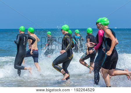 Kijkduin The Hague the Netherlands - 17 June 2017: Kijkduin cross triathlon athletes running into the sea for swimleg
