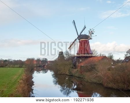 Greetsiel Germany - December 6 2014: Traditional Windmill working and still used to grind. The second mill is currently under renovation due to a violent hurricane.